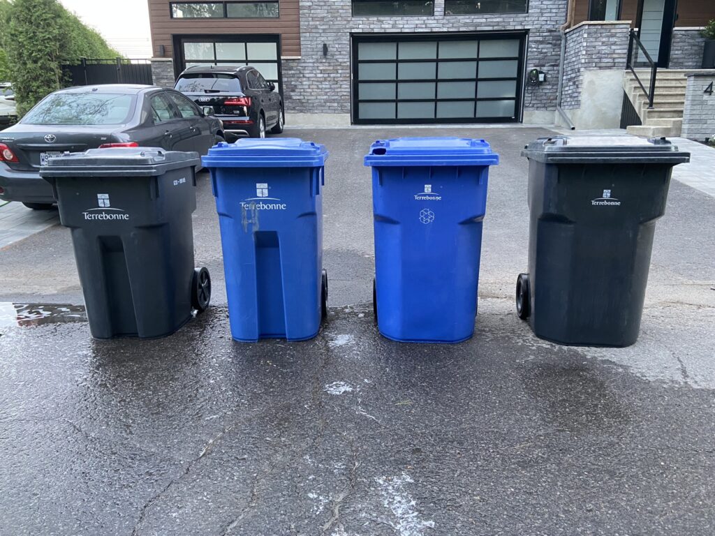 Bacs de poubelle et recyclage propre devant une maison